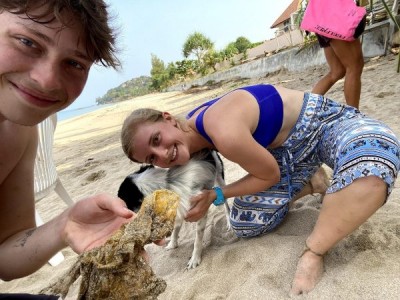 Shane and Addie take a selfie with a dog and their mostly-destroyed mango.