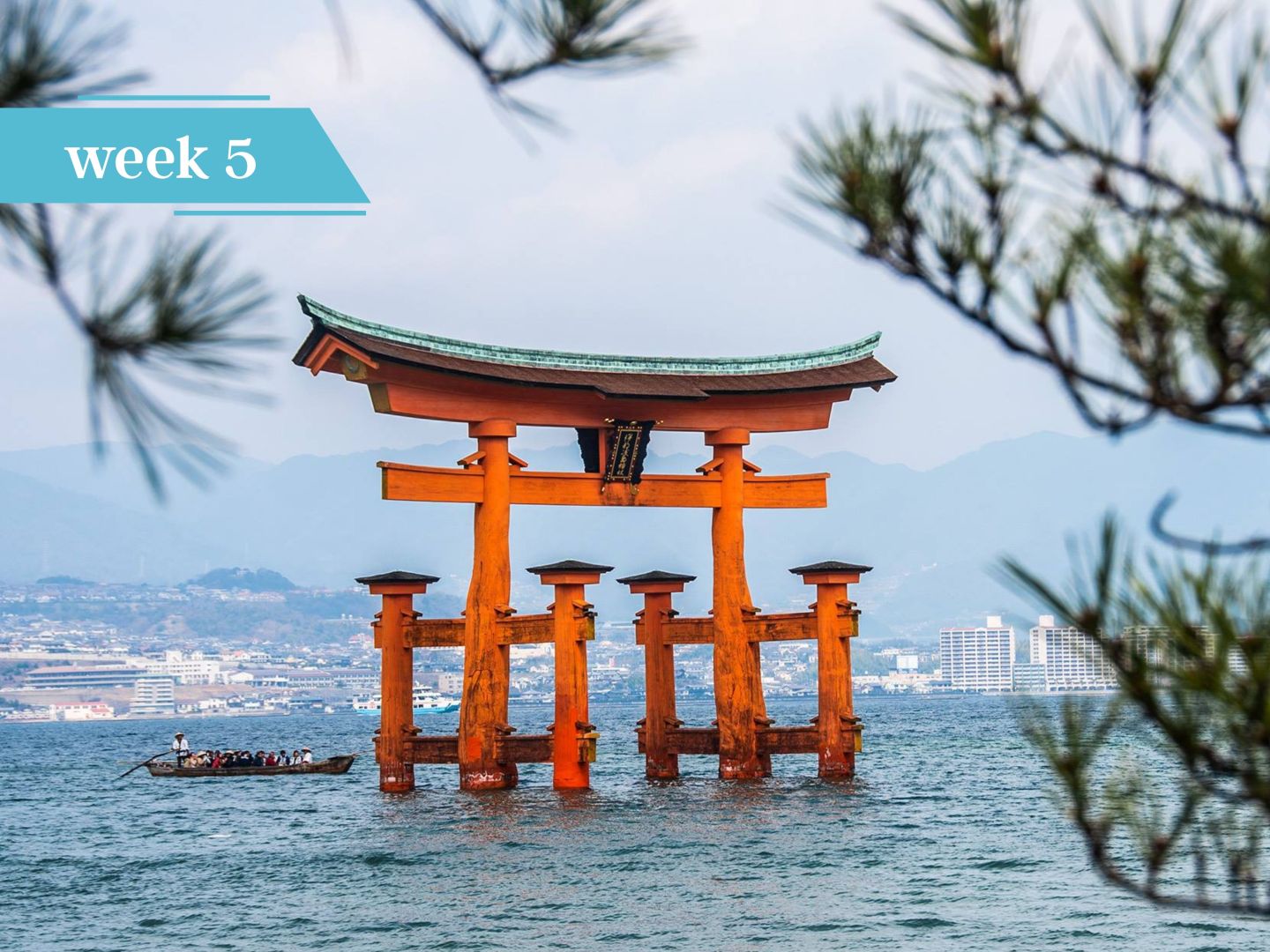 Orange torii gate standing in the sea with a small boat nearby
